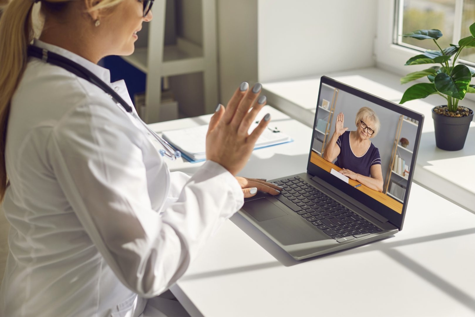 Doctor consulting with elderly patient via telehealth